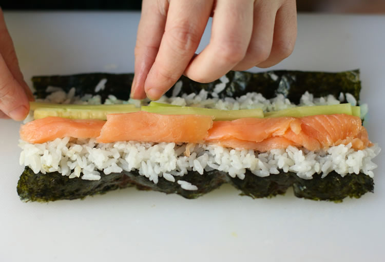 making a smoked salmon and cucumber roll