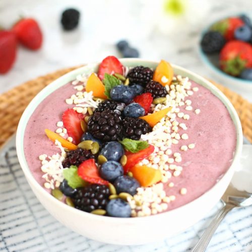 Mixed Berry and collagen peptide smoothie bowl topped with strawberries, blackberries, apricots, shredded coconut and pumpkin seeds.